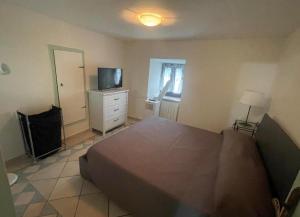 a bedroom with a bed and a dresser with a television at Mission Holiday in Penna in Teverina