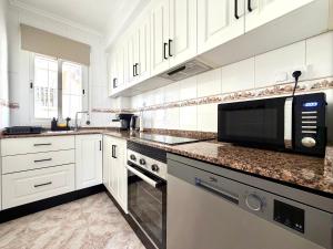 a kitchen with white cabinets and a microwave at Villa Emika with private pool in Ciudad Quesada in Ciudad Quesada +17 photos