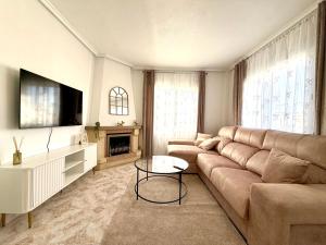 a living room with a couch and a table at Villa Emika with private pool in Ciudad Quesada in Ciudad Quesada