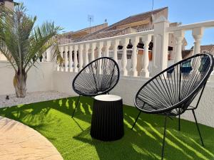 two chairs and a stump in a yard with grass at Villa Emika with private pool in Ciudad Quesada in Ciudad Quesada