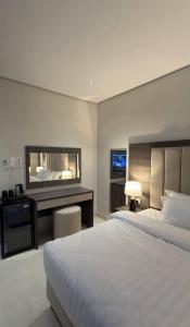 a hotel room with two beds and a desk at جودول للشقق المخدومة in Khafji