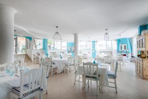 a dining room with white tables and chairs at Marechiaro Pool & Restaurant in Paestum +22 photos