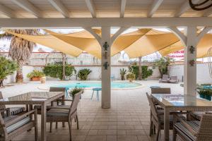 a patio with tables and chairs and a pool at Marechiaro Pool & Restaurant in Paestum