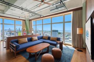 a living room with a blue couch and large windows at South Gate Hotel Okinawa Naha Tomari Port - Direct Access to Tomarin in Naha