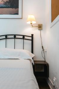 a bedroom with a bed with a lamp on the wall at Corfu Dream Holidays Villas in Glyfada