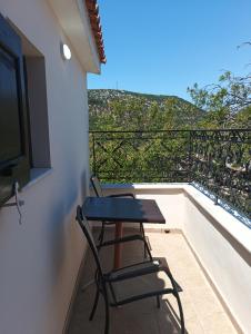 ein Balkon mit zwei Stühlen und einem Tisch auf einem Dach in der Unterkunft AZRA studios in Mytilini