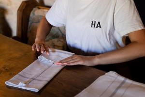 a man standing at a wooden table holding a pair of socks at The Harcourt Arms in Witney
