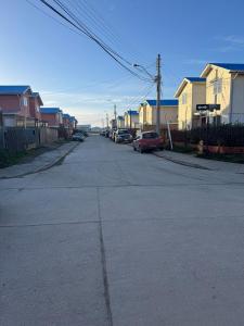 an empty street with houses and cars parked on it at Casa 2 dormitorios - Punta Arenas - Río Seco in Punta Arenas