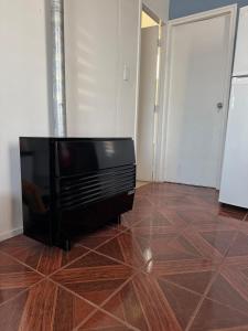 a flat screen tv sitting on top of a wooden floor at Casa 2 dormitorios - Punta Arenas - Río Seco in Punta Arenas