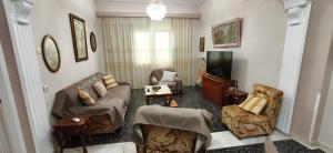 a living room with a couch and a tv at Mama's Home in Chios