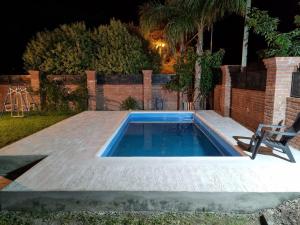 a swimming pool in a backyard at night at Cata, Casa de Descanso in Salta