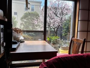 a room with a table and a window with a tree at スペースigusa専用寝室2室に2名様3泊よりマンスリー割引がおすすめ in Tokyo