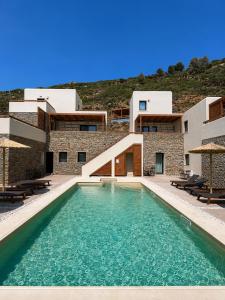 a swimming pool in front of a building at Alia Andros in Vitálion
