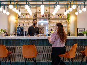 Ein Mann und eine Frau stehen an einer Bar in der Unterkunft Mercure Brussels Centre Rogier in Brüssel