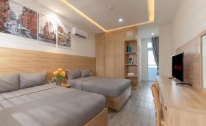 a hotel room with two beds and a television at Nha Trang Center Point in Nha Trang +19 photos