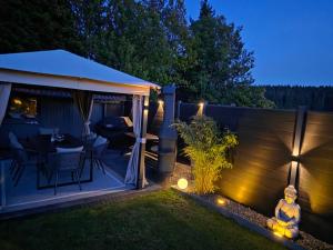 a garden at night with a gazebo and a table at Ferienglück Vogelsang in Loßburg