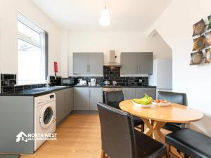 a kitchen with a table and chairs and a dining room at Leigh 2-Bedroom House Near Haydock & Wigan in Leigh