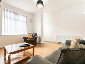 a living room with a couch and a table at Leigh 2-Bedroom House Near Haydock & Wigan in Leigh