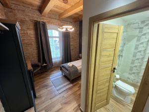 a room with a bathroom with a toilet and a bedroom at Tejmalom Szálló in Sárrétudvari