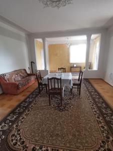a dining room with a table and chairs and a couch at Фазенда Оганеса in Ureki