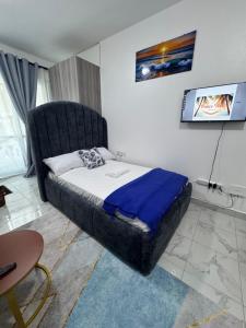 a bedroom with a bed with a black headboard at Peace Nest bamburi in Mombasa