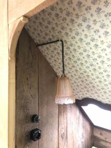 a lamp hanging from a wall next to a door at Chez Oma, La petite ferme in Weinbourg