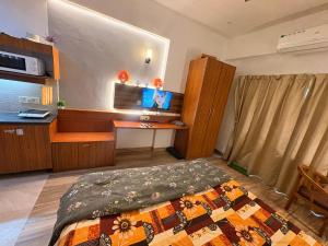 a bedroom with a bed and a desk with a computer at Skyline suites in Greater Noida