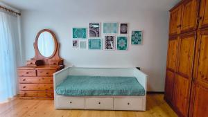 a room with a bed with a mirror and a dresser at Casa Pal Piccolo - Apartment with garage for bikes and fast wifi in Paluzza