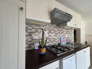 a kitchen with a black counter top and a stove at Tranquil garden hideaway in Gozo in San Lawrenz