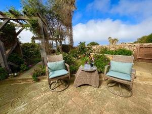 a patio with two chairs and a table at Tranquil garden hideaway in Gozo in San Lawrenz