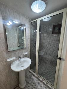 a bathroom with a shower and a sink and a glass shower stall at Tranquil garden hideaway in Gozo in San Lawrenz