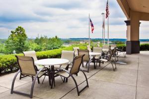 a row of tables and chairs on a patio with flags at FairBridge Inn & Suites Independence in Cleveland