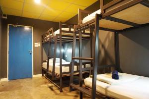 B&B House & Hostel في مينْغكرابي: غرفة بها ثلاثة أسرة بطابقين وباب أزرق
