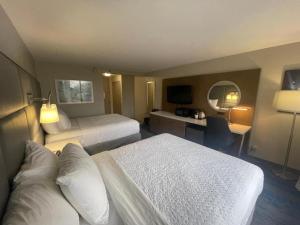 a hotel room with two beds and a desk at FairBridge Inn & Suites Independence in Cleveland +15 photos