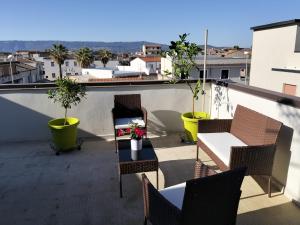 a balcony with chairs and tables and potted plants at Una Terrazza sul mare in San Ferdinando
