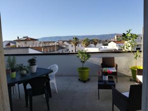 a balcony with tables and chairs and a view of a city at Una Terrazza sul mare in San Ferdinando