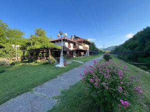 a house with a pathway in front of a yard at Vodenica kod Uče in Gukoš +12 photos