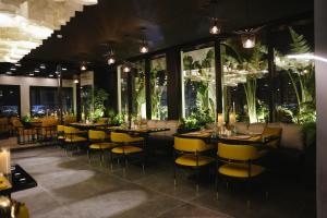 a restaurant with tables and yellow chairs and windows at Youssif Hotel in Dakākīn Ḩamīd