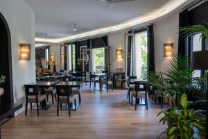 a dining room with tables and chairs and plants at Hotel Paseo de Gracia in Barcelona