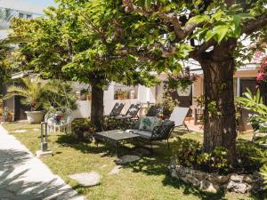 a garden with a bench under two trees at Hôtel La Villa Cannes in Cannes