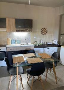 a kitchen with a table and chairs and a sink at Villa J&C-SAINT AIMILIANOS in Porto Heli