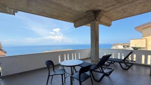 a balcony with a table and chairs and the ocean at Torre Antica in Ioppolo