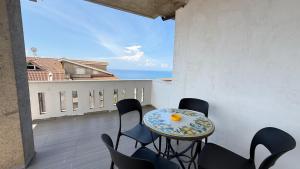 a balcony with a table and chairs and the ocean at Torre Antica in Ioppolo