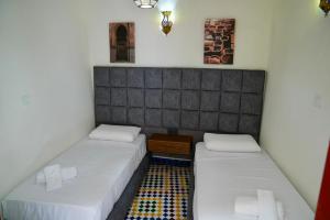 two beds in a small room with at Riad Chouara in Fez