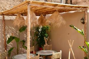 a pergola with two tables and some plants at Riad Chouara in Fez