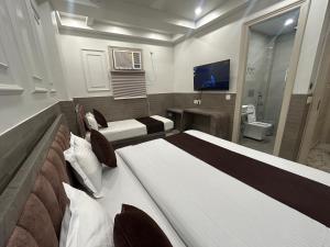 a hotel room with two beds and a tv at Grand Tree Hotel Shree Guru in New Delhi