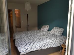 a bedroom with a bed and a blue wall at Verborgen Pareltje in Bray-Dunes