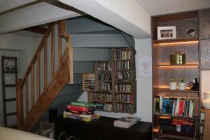a living room with a staircase with bookshelves at Verborgen Pareltje in Bray-Dunes