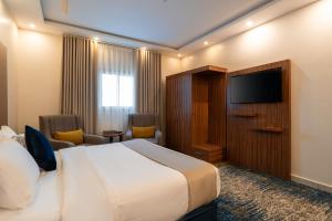 a hotel room with a bed and a flat screen tv at القصر الإسكان in Khamis Mushayt +16 photos