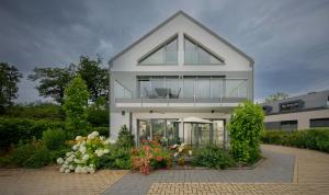a white house with flowers in front of it at Lindenberg Apartments in Wernigerode